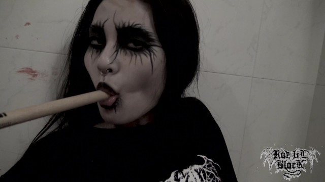 A girl in the bathroom masturbates her wet pussy with a stick, smearing black makeup around her eyes